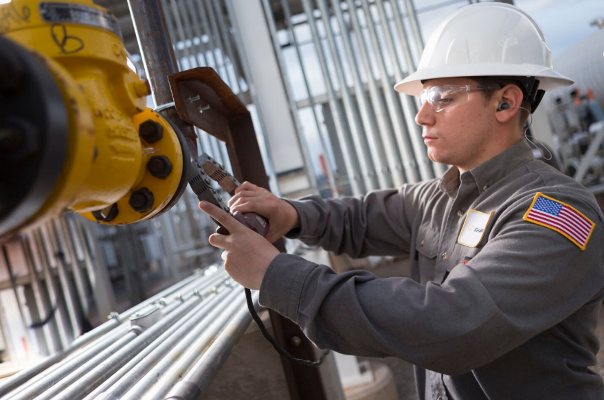 Technician applying lubricant to industrial steel wire rope for corrosion protection and improved performance